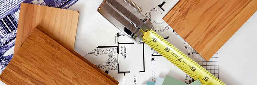 Tools and lumber on top of home improvement blueprints.