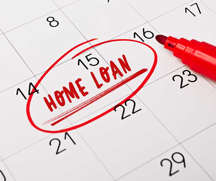 Closeup of a personal calendar; the phrase Home loan written in red text on a calendar page as a reminder.